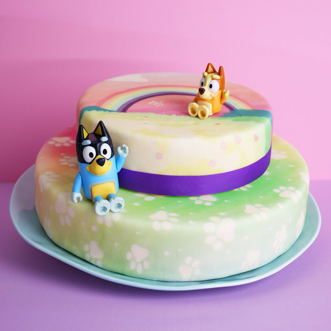 Figurine Bluey® sur gâteau arc-en-ciel 2 étages