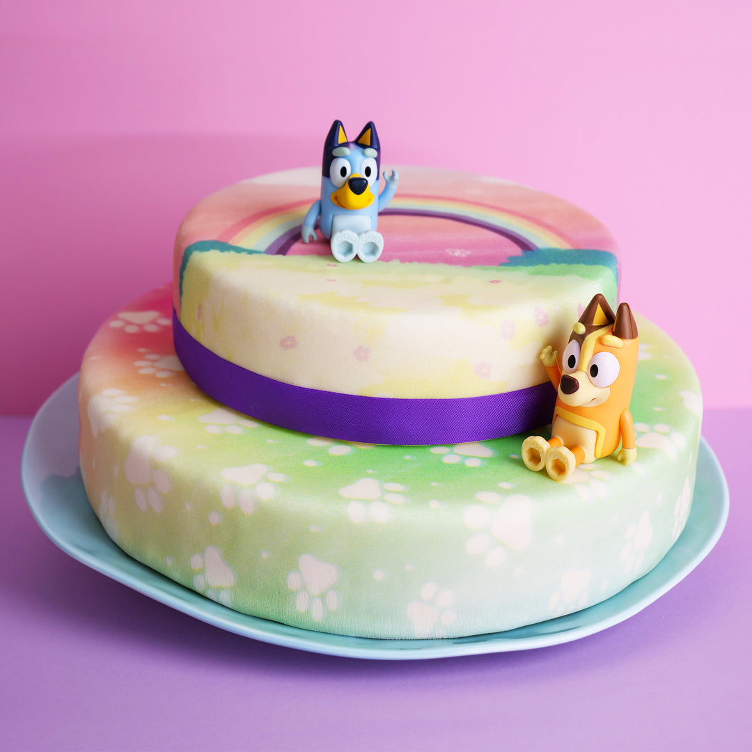 Figurine Bluey® sur gâteau arc-en-ciel 2 étages